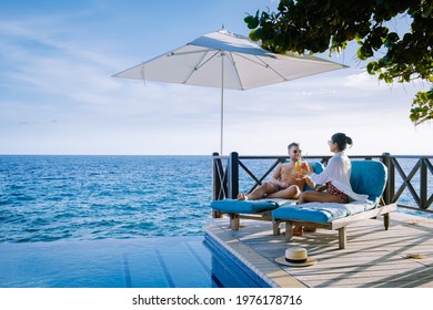 Curacao, couple man and woman mid age relaxing by the swimming pool during vacation, men and girl by pool in Curacao during holiday at a tropical island luxury vacation