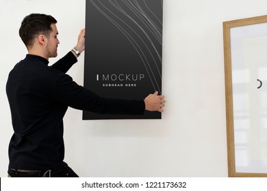 Curator Hanging An Art Piece Mockup On The Wall In A Gallery