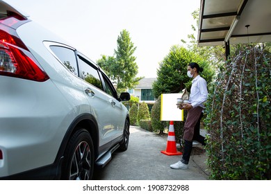 Curbside pick up.Store worker prepare and hold foods from customer order online delivery to customer in the outside.Social distance and contactless prevent covid-19.
