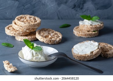 Curd cheese and whole grain crispbreads on a gray table
