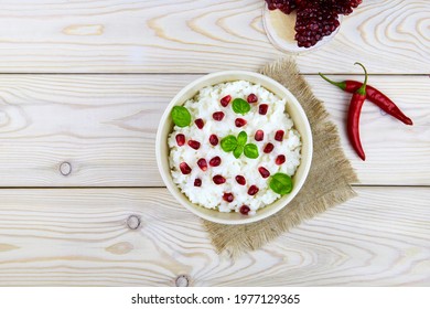 Curd rice in a ceramic bowl on a white wooden background. A popular dish from South India with rice, yogurt, spices, pomegranate. 