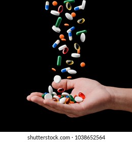 Cure for all diseases. Pills falling onto man's hand, isolated on black. Modern medicine and new solution.