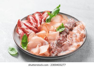 Cured Meat Platter, Antipasto Set, Appetizer Variety on Plate over Grey Concrete Background - Powered by Shutterstock