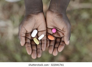 Curing Malaria - African Girl Holding Pills Medicine Health Symbol. Medicine And Healthcare Pills Are Very Important In The Black Continent. 