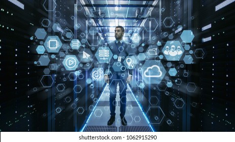 Curios IT Engineer Standing in the Middle of a Working Data Center Server Room. Cloud and Internet Icon Visualisation in the Foreground.