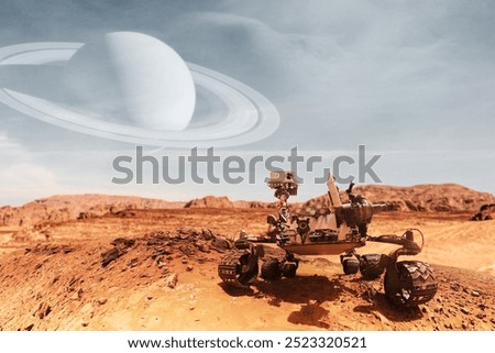Curiosity Mars Rover exploring the surface of red planet with Saturn planet background. Elements of this image furnished by NASA.