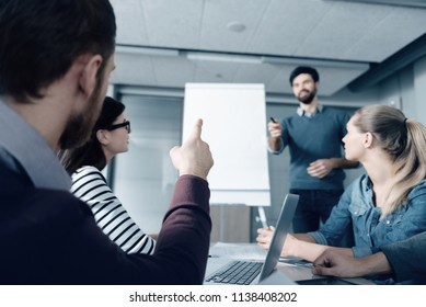 Curiosity Wins. Close Up Of A Pleasant Man Asking Questions While A Professional Man Conducting A Presentation In The Office