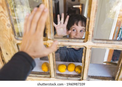 A Curious Boy Looks Out The Window, Portrait Of A Boy, Observation Through The Window, The Emotions Of A Child, Kid Looks Out Of The Window Of A House, Quarantine Self-isolation, Boy Waving.