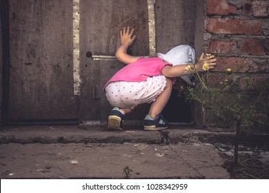 Curious child lookinginto dark hole in barn door in countryside shed concept curiosity