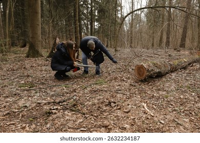 Curious Couple Exploring Fallen Tree in Forest Using Stick During Nature Walk on Early Spring Day