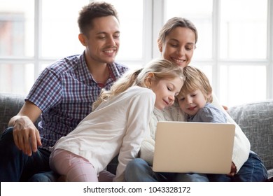 Curious Cute Little Children Boy And Girl Peeking On Laptop While Parents Doing Online Shopping Or Using Computer Applications, Happy Family With Son And Daughter Enjoying Leisure At Home With Pc