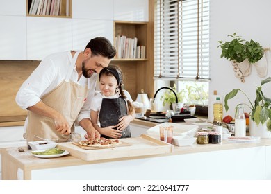 Curious daughter kid watching process dad cutting homemade pizza in pieces. Happy parent teaching daughter baking pizza inj modern light kitchen with large window. Happy family preparing dinner. - Powered by Shutterstock