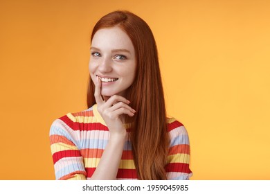Curious devious redhead young 20s girlfriend have excellent idea smirking tricky touch lip flirty mysteriously glancing camera have plans preparing interesting surprise, standing orange background