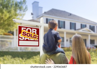 Curious Family Facing Sold For Sale Real Estate Sign And Beautiful New House.