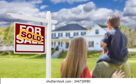 Curious Family Facing Sold For Sale Real Estate Sign And Beautiful New House.