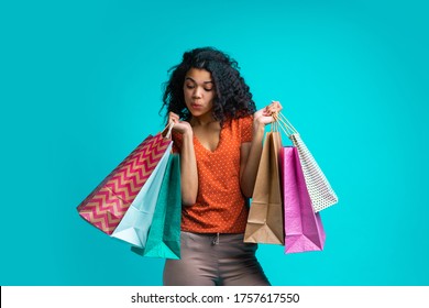 Curious And Flirty Dark Skinned Girl Looking Into One Of The Shoping Bags She's Holding Checking Her Purchases.