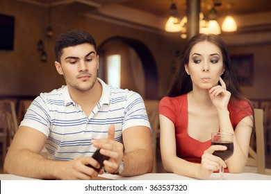 Curious Girl Spying Boyfriend on Smartphone - Secretive couple having a bad date in a restaurant
