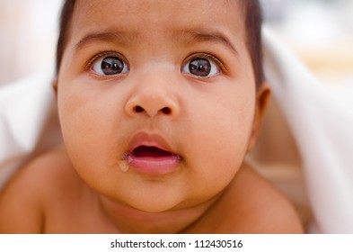 Curious Indian Baby Girl Drooling And Looking At Camera