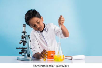 Curious little Indian asian school kid or scientist studying science, experimenting with chemicals or microscope at laboratory, selective focus - Powered by Shutterstock