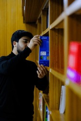 Male student selecting book, a School & Education Photo by Jacob Lund