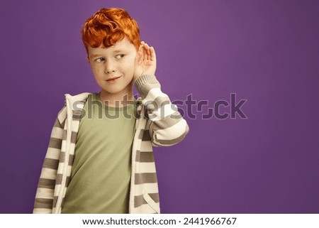 Curious Red Haired Boy Likes Gossips, Wants to Overhear Secret Information, is Overcoming by Curiosity, Tries to Hear adult Conversation, Listens Attentively Keeps hear Hand near Ear Eavesdropping 
