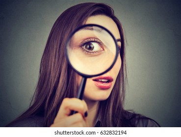 Curious woman looking through a magnifying glass 
