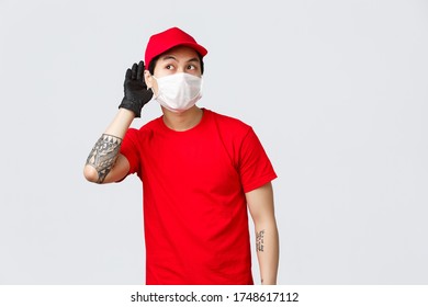 Curious Young Asian Delivery Guy Eavesdropping, Wear Protective Gloves And Medical Mask, Leaning Towards Wall Or Door To Overhear Conversation, Listen Closely Intrigued, Likes Gossips At Work