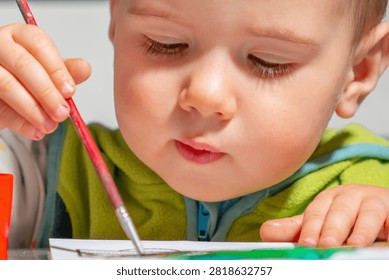 Curious young boy developing imagination with colorful watercolor painting.