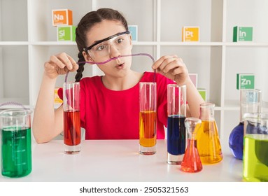 Curious young girl wearing safety goggles and conducting a colorful chemistry experiment with test tubes in a laboratory setting. - Powered by Shutterstock