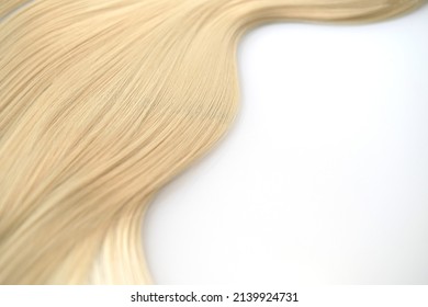 Curl female healthy hair. Concept hairdresser spa salon. strand of blond silky hair on a white background. Mock up for design. Real photo, mockup template, isolated on light grey background.