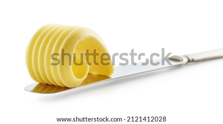 curl of fresh butter on a knife isolated on white background