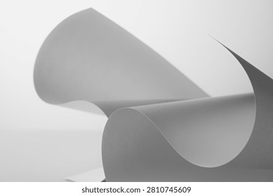 Curled white paper forms with soft gray shadows creating abstract minimal background for design mockup
