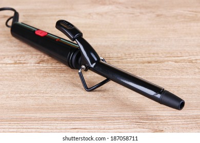 Curling Iron  On Wooden Background