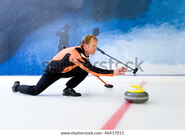 Curling player delivering a stone on a curling rink,\
sliding over the ice