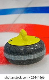Curling rock sits near the button during a league game