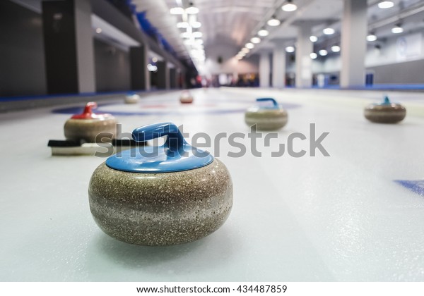 Curling stones lined\
up on the playing field