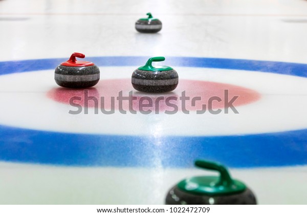 curling stones on the\
ice