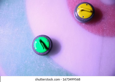 curling stones on ice near the home colorful background 