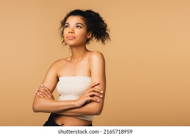 curly african american woman with bare shoulders posing with crossed arms isolated on beige - Shutterstock ID 2165718959