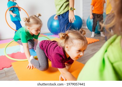 Curly girl crawling on colorful floor through hula hoops - Powered by Shutterstock