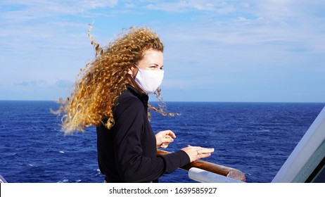 Curly girl in a medical respirator on board a cruise ship on a sunny day against the background of the sea. quarantined european girl cruise ship
