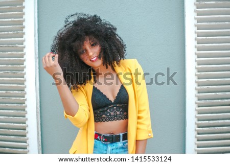 Similar – Young woman with curly hair near a modern colorful building