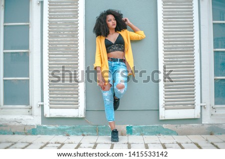 Similar – Young woman with curly hair near a modern colorful building