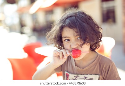 Curly Hair Mixed White Caucasian And Asian Kid,boy,child Enjoy Popsicle Ice Cream In The Hot Summer Day And Strong Sunshine With Happiness In Toned Color And Selective Focus