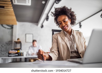 Curly hair woman holding pen and reading something from paper. - Powered by Shutterstock