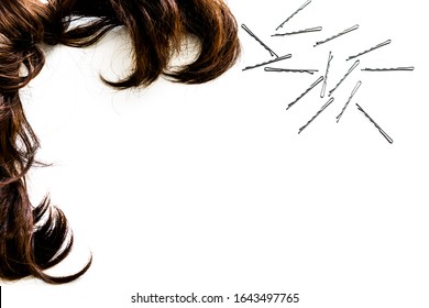 Curly Locks Of Brown Hair And Bobby Pins On White Isolated Background For Copy Space