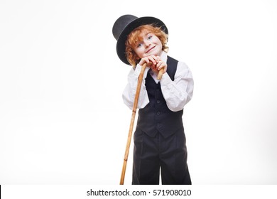 Curly Red-haired Boy, Handsome, Stylishly Dressed Boy With Red Hair In A Hat, Child With A Cane In His Hand Dressed In A Black Suit Isolated On White Background, Little Actor.