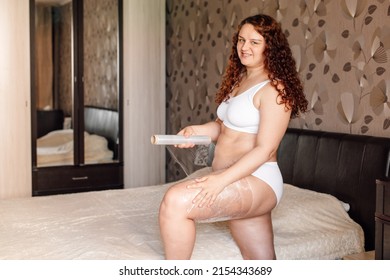 Curly Smiling Plus Size Woman In White Underwear Stand Near Bed In Bedroom And Wrap Hip With Cling Film. Fat Burning Treatment Of Thick Thighs And Legs. Weight Loss Program, Body Wrap Procedure.