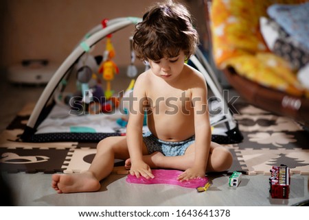 Similar – Baby Mädchen spielt mit Haarspangen, die auf dem Boden liegen.