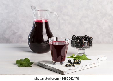 Currant juice in a glass on a light background.